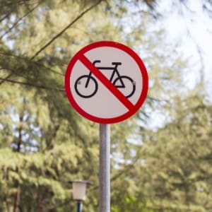 OBBBA and Transportation benefits; a "no bicycle" sign with a red line slashed through a bike