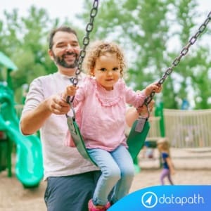 Dependent Care FSA limit increase; man playing with young daughter on a swingset